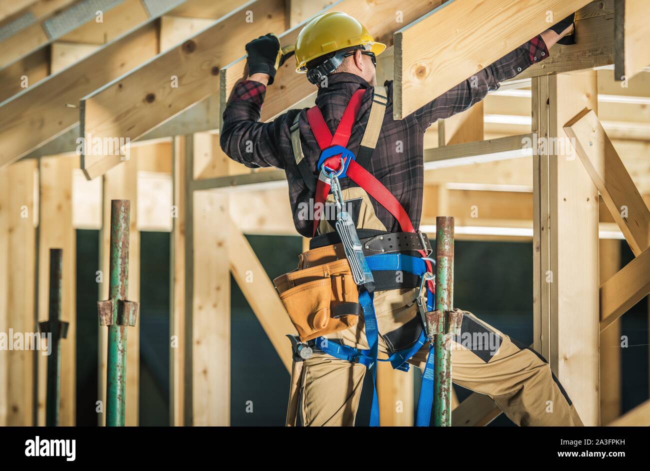 Wood House Frame Construction. Caucasian Carpenter Contractor and His Job. Industrial Theme. Stock Photo