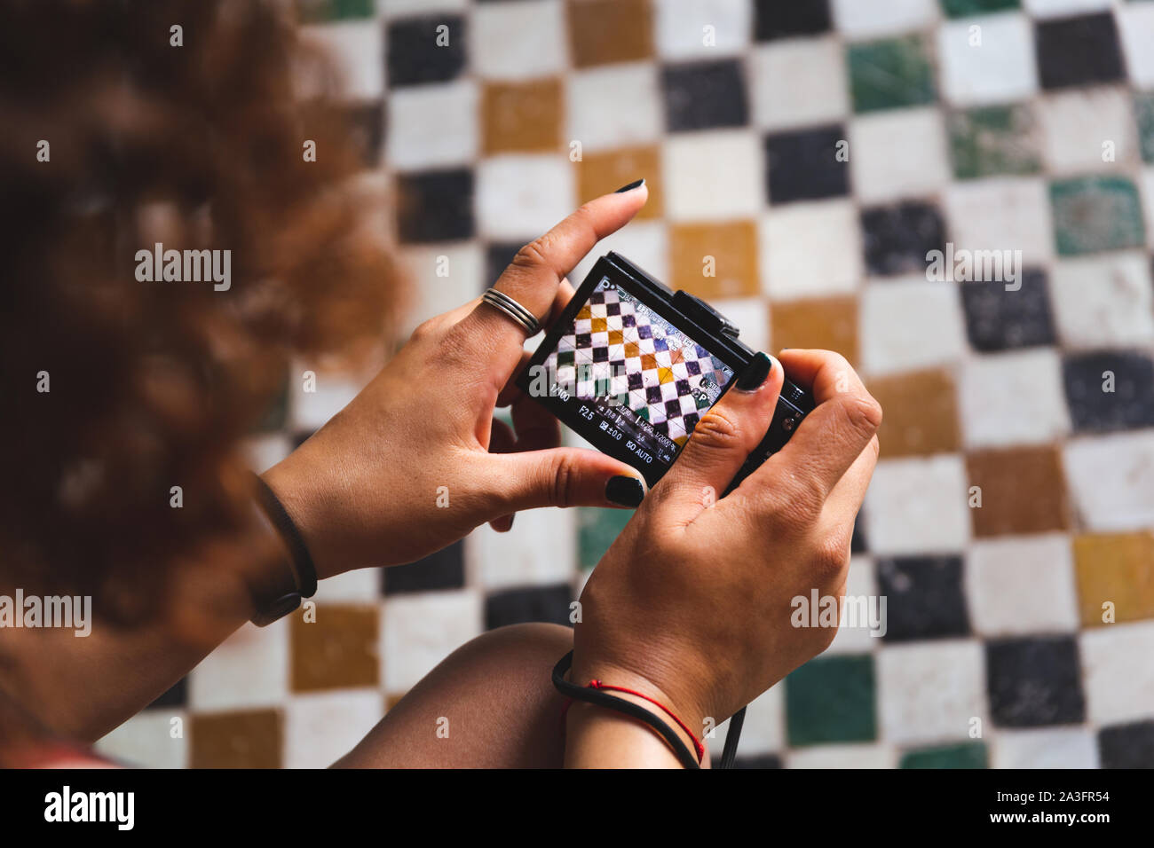 close up of woman's hands holding point and shoot camera photographing