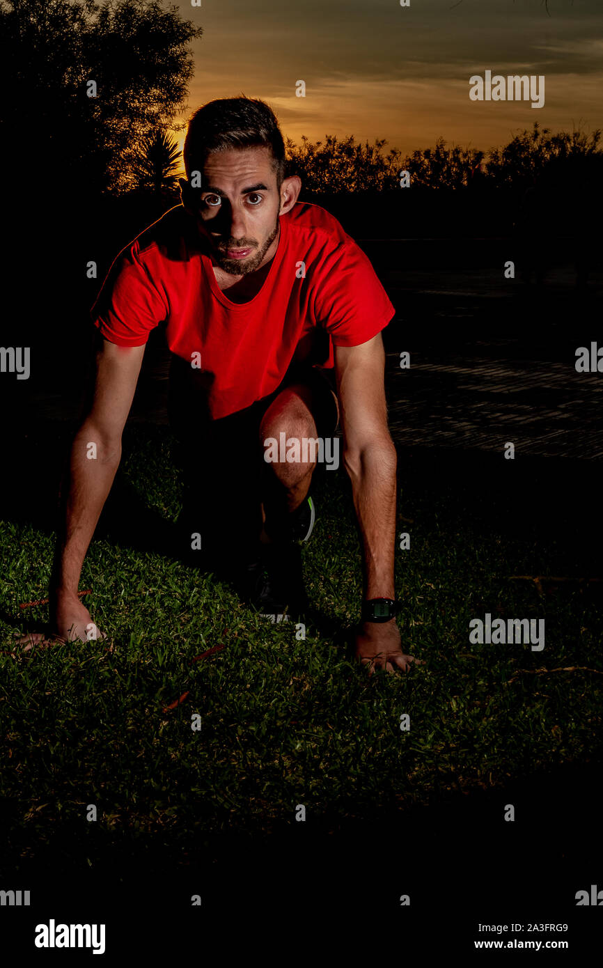 athlete placed in the starting position of a race on green grass Stock Photo