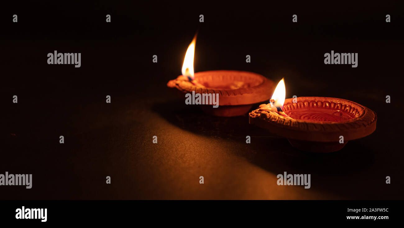 Diwali, Hindu festival of lights. Clay diyas candles illuminated in Dipavali. Oil lamps on traditional tray, copy space Stock Photo