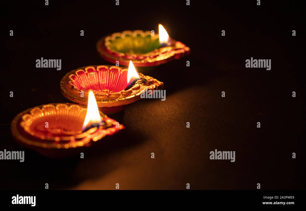 Diwali, Hindu festival of lights. Clay diyas candles illuminated in Dipavali. Oil lamps on traditional tray, copy space Stock Photo