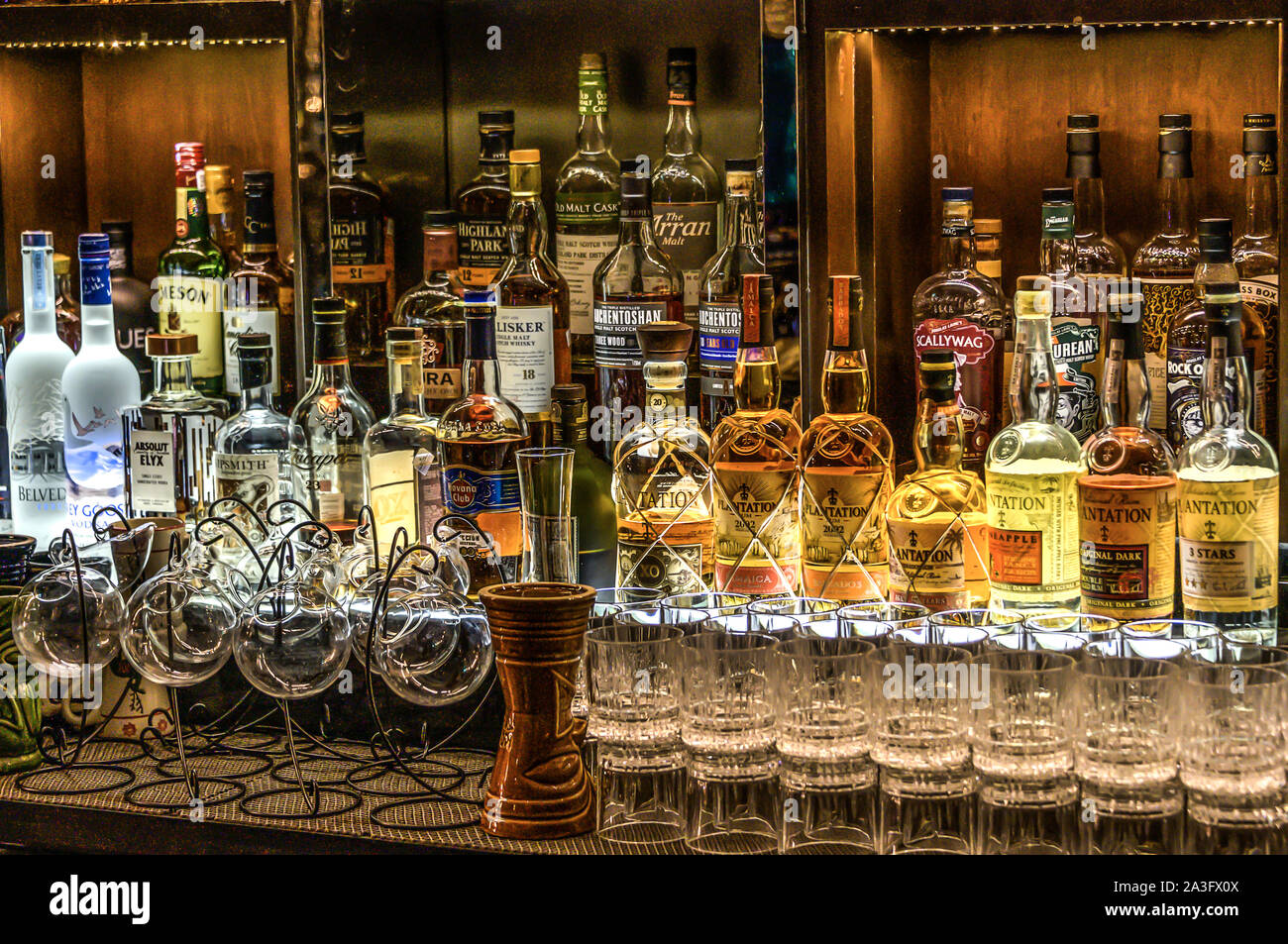 24.02.2019 Peking China - Wall with Bitters and alcohols whiskey bar counter bottles ambient tlight blurred background. Stock Photo