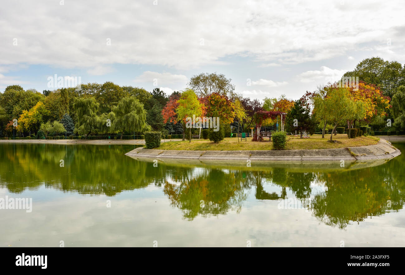 Outdoorsfall landscape, trees on a small island on a lake of a recreational park in Ploiesti City , Romania Stock Photo