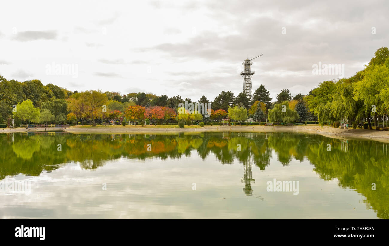 Autumn landscape with season colored foliage of the trees and water reflection, recreational park in Ploiesti City , Romania Stock Photo