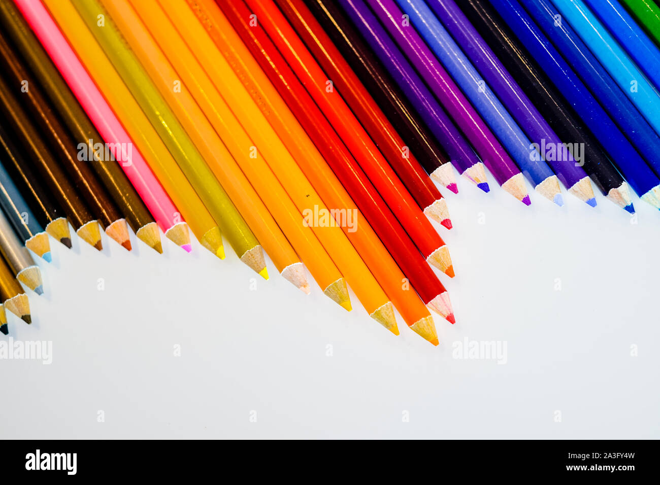 Line of color pencils isolated on white background. Close up. Copy ...