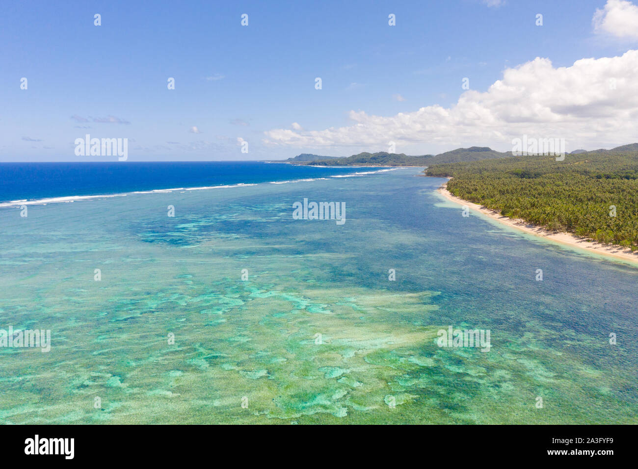 Seascape, coast of the island of Siargao, Philippines. Blue sea with waves and sky with big clouds, top view. Stock Photo