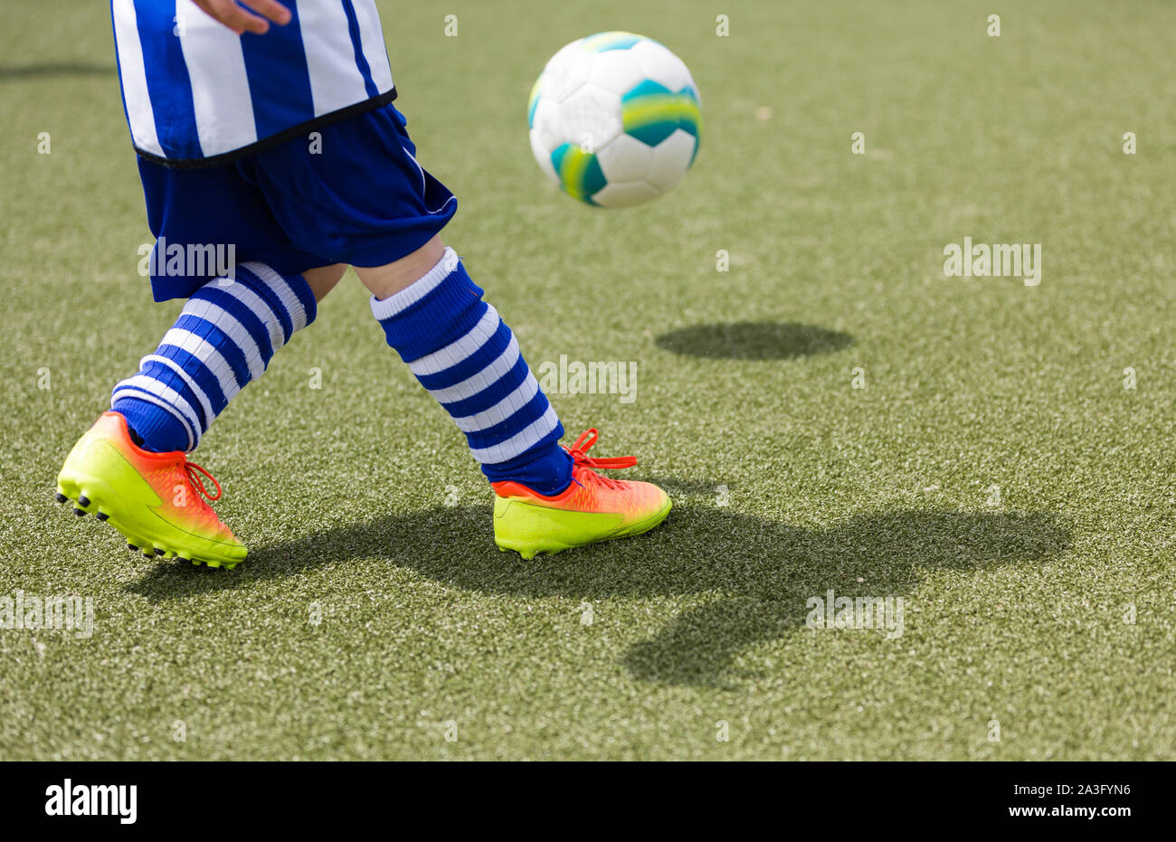 young boy playing soccer on artificial turf Stock Photo