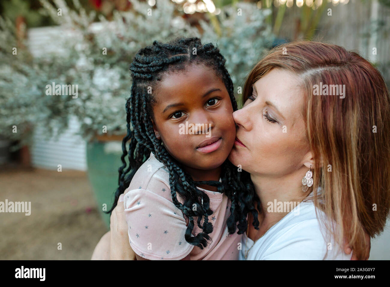 Sweet black daughter and loving white mom hugging Stock Photo