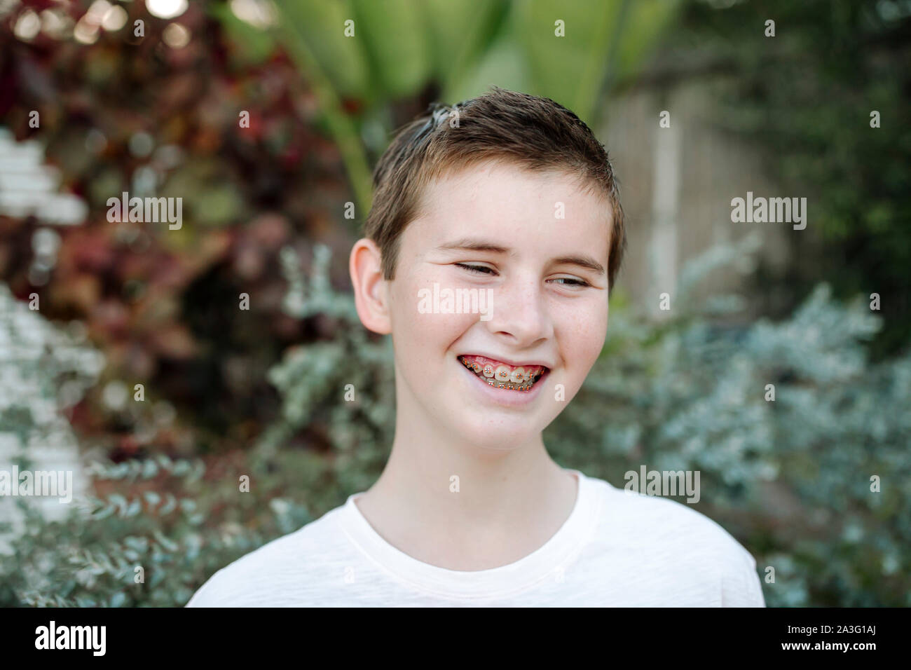 Smiling preteen boy with short hair and braces Stock Photo