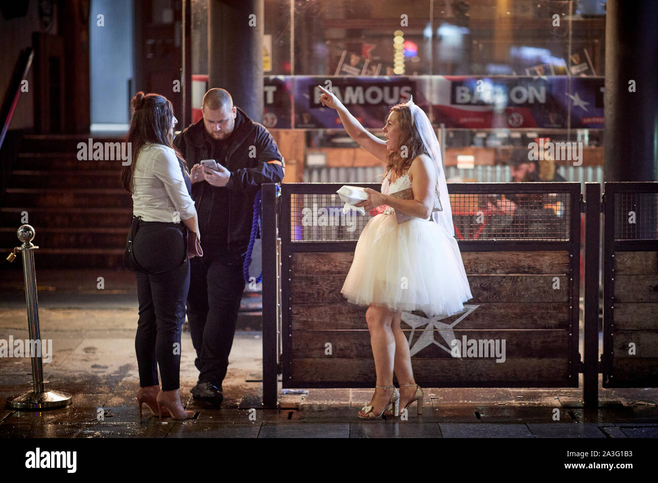 Cardiff Wales, dressed as a bride, hen party chatting to doorman Stock Photo