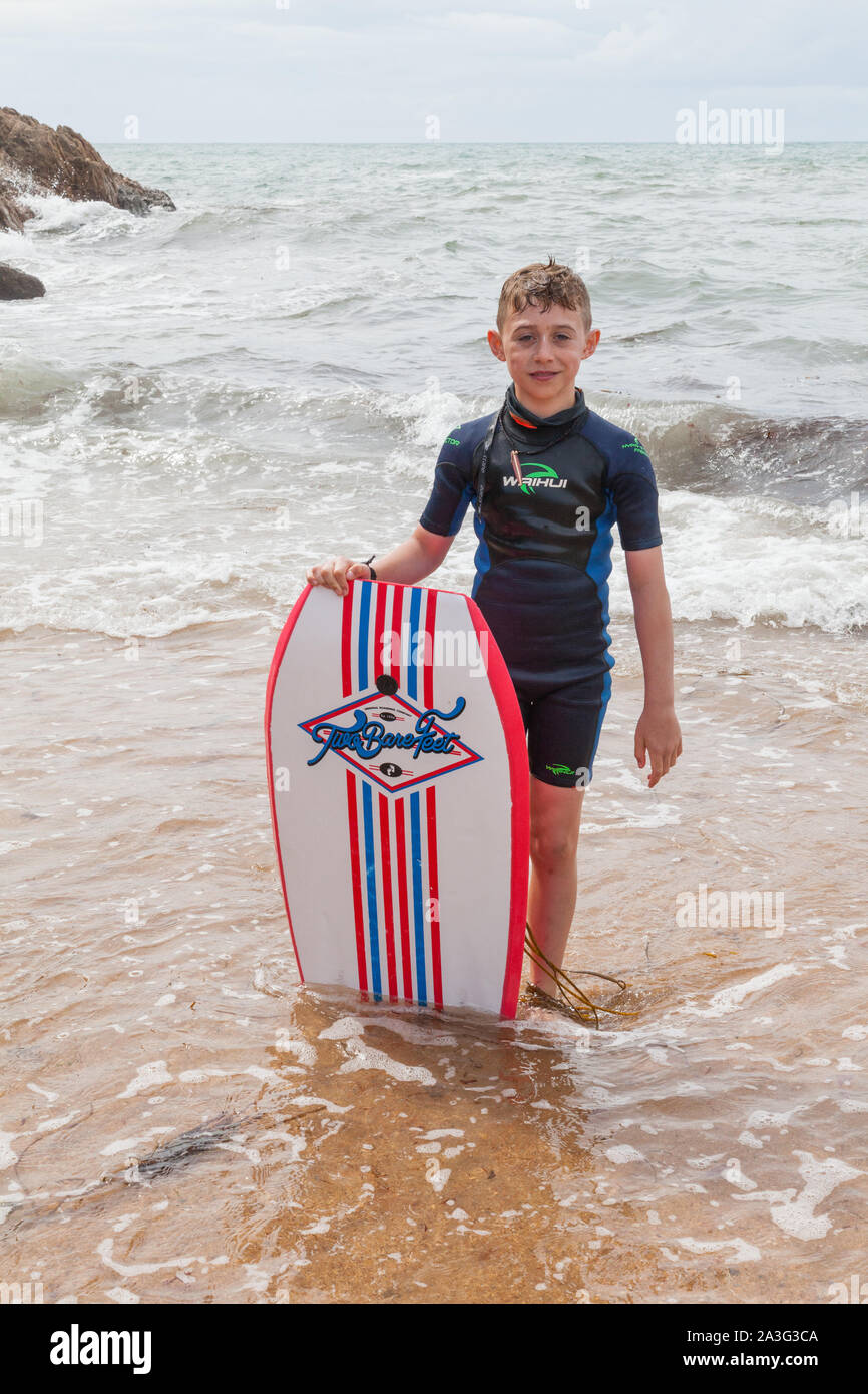Ten year old boy surfing at Outer Hope Cove, Mouthwell sands beach