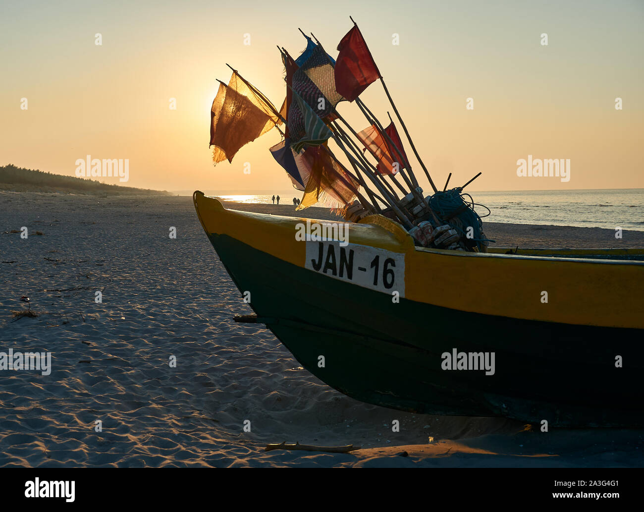 Traditional Polish fishing boat (Kuter) during a sunset on a beach near the town of Jantar, Poland. Stock Photo