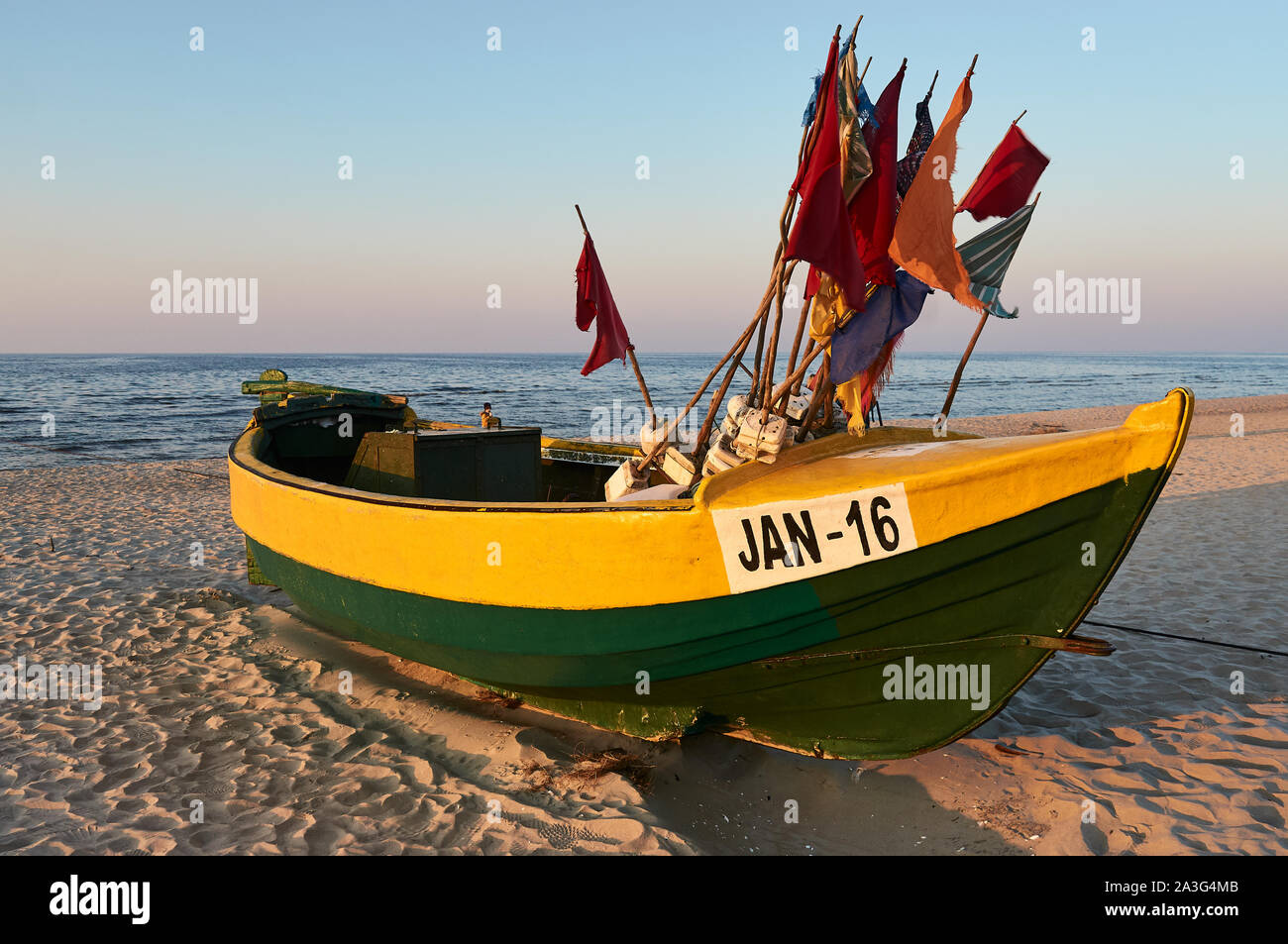Traditional Polish fishing boat (Kuter) during a sunset on a beach near the town of Jantar, Poland. Stock Photo