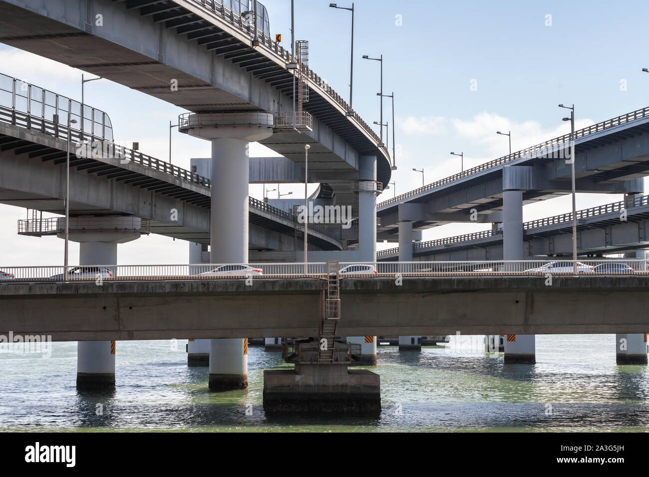 Road junction with cars at the entrance to the Gwangandaegyo or Diamond Bridge in foggy evening. Busan, South Korea Stock Photo