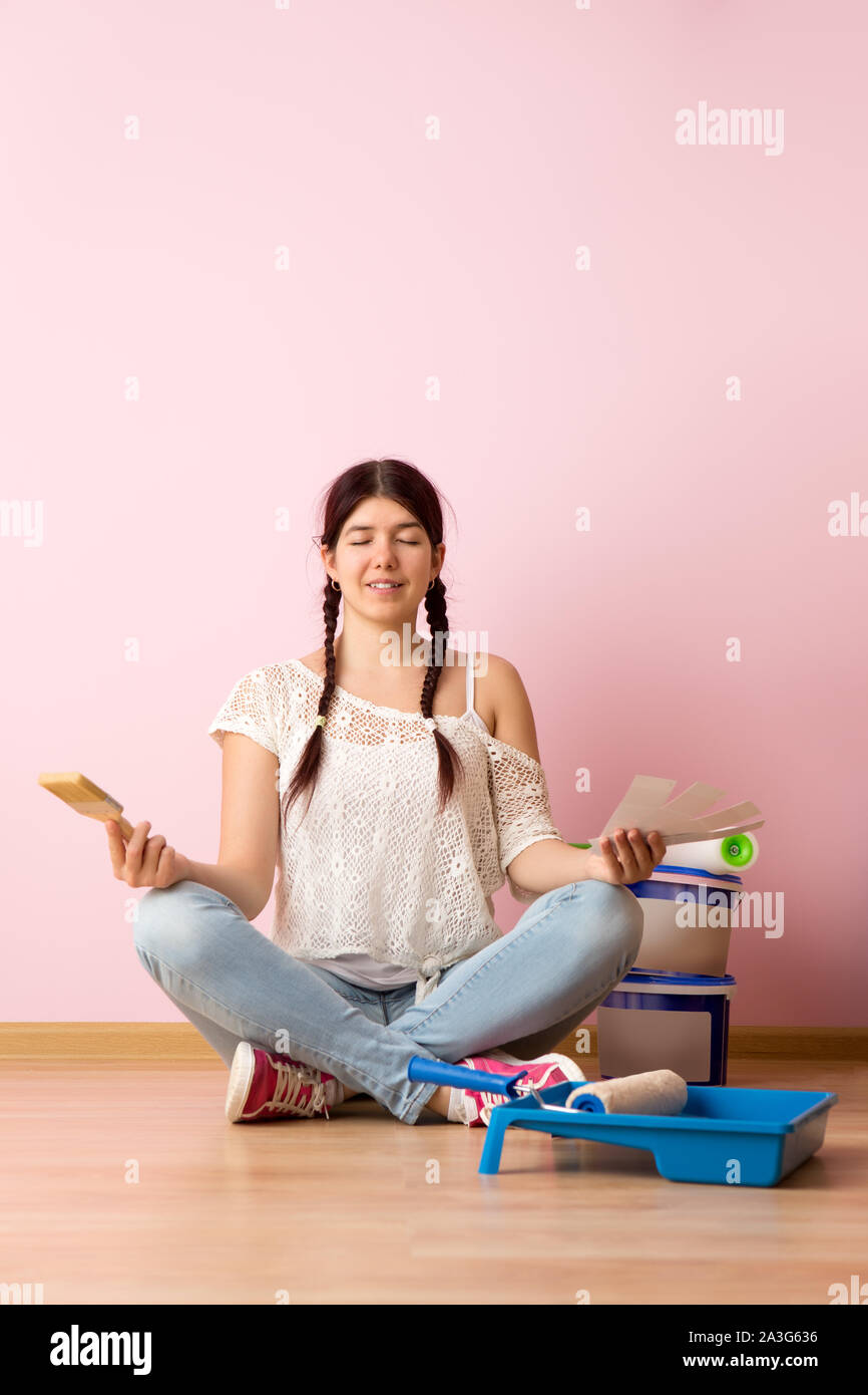 Woman with brush and color palette sitting on the floor in new ...