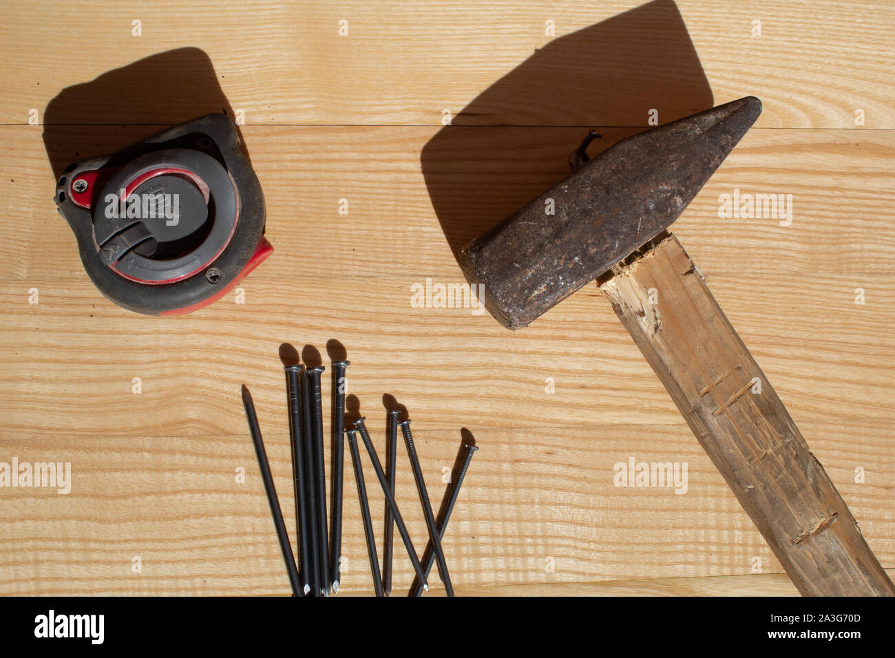 Hammer nails and tape measure on wooden table Stock Photo