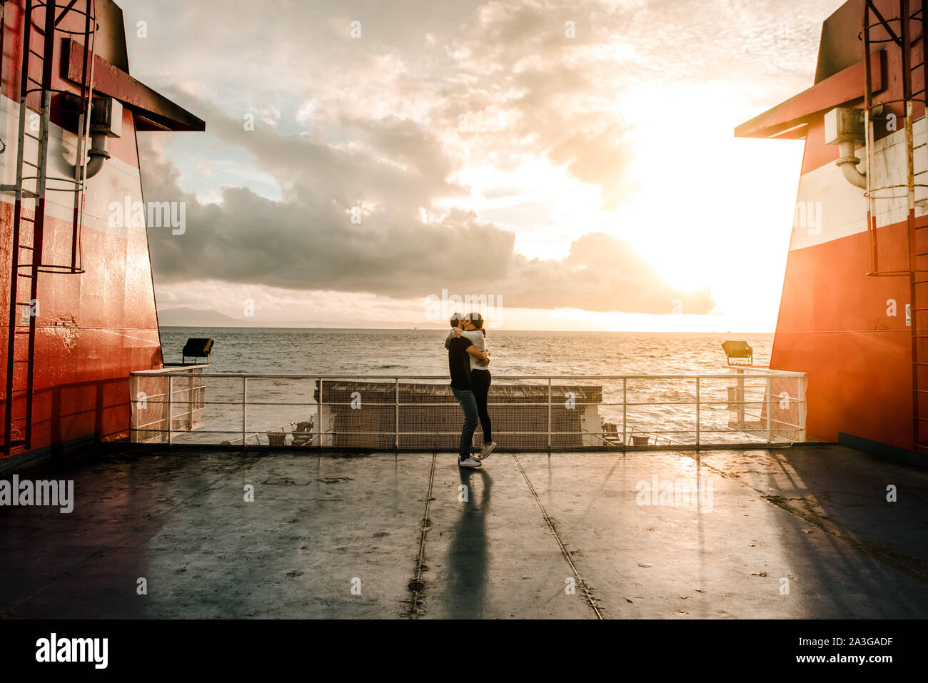 couple hugging in a boat with a sunset in the background Stock Photo ...