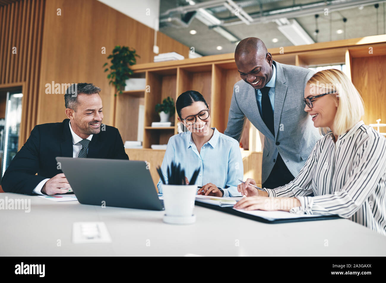 Diverse group of businesspeople laughing while having a meeting ...