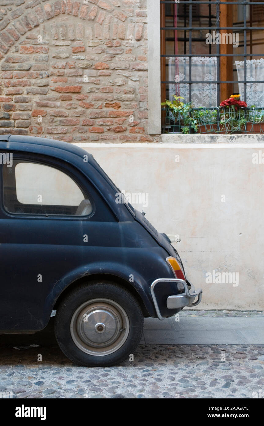 Old fashioned car (Fiat 500)  parked in front a house, Italy Stock Photo