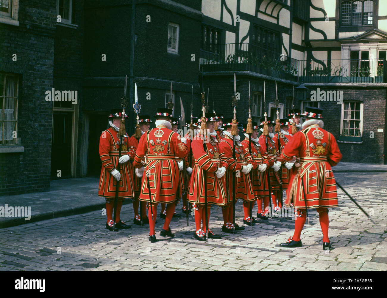 1960s, historical picture of Yeomen Warders in Tudor state dress. The warders are ceremonial guardians of the Fortress of the Tower of London, a duty dating back to Tudor times. All warders are retired from the Armed Forces of Commonwealth realms. Stock Photo