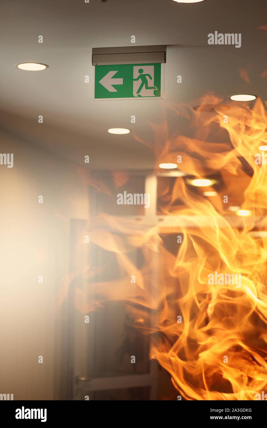 Evacuating sign in office builging while fire Stock Photo