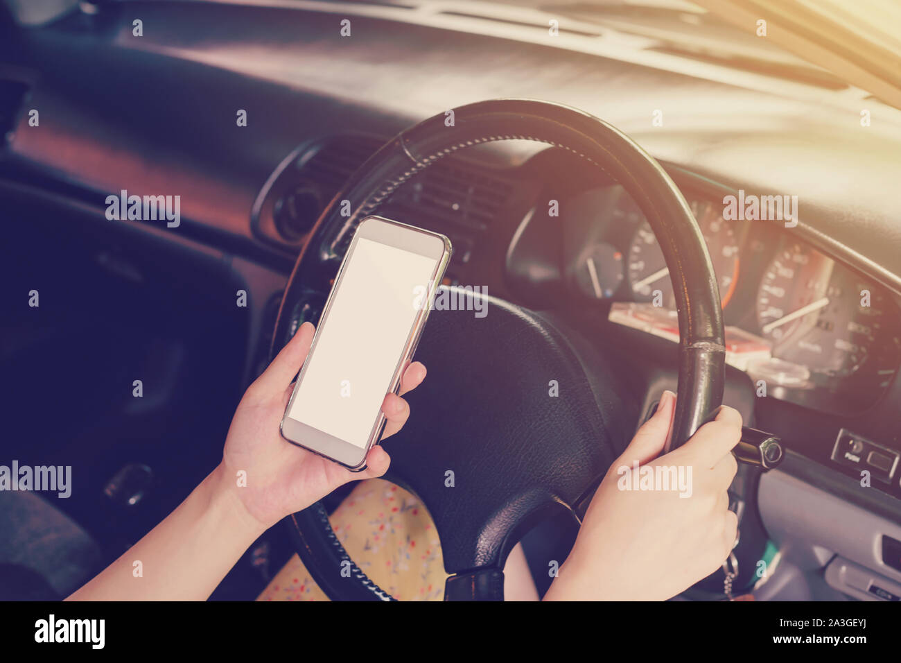 woman driver hands holding steering wheel driving and holding phone in
