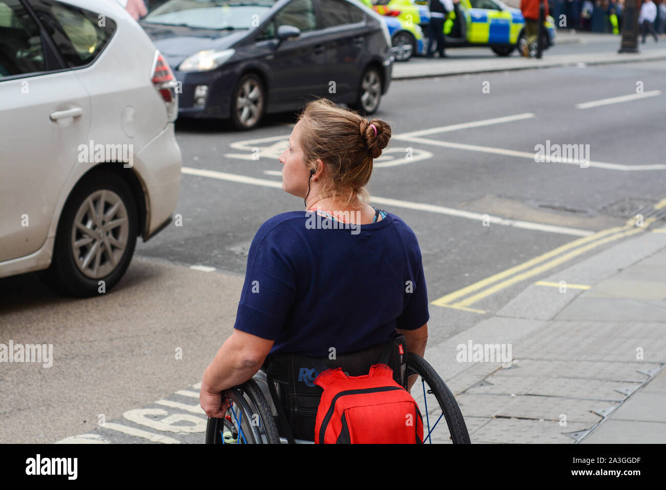 Woman disabled in wheelchair is crossing the street alone Stock Photo Alamy