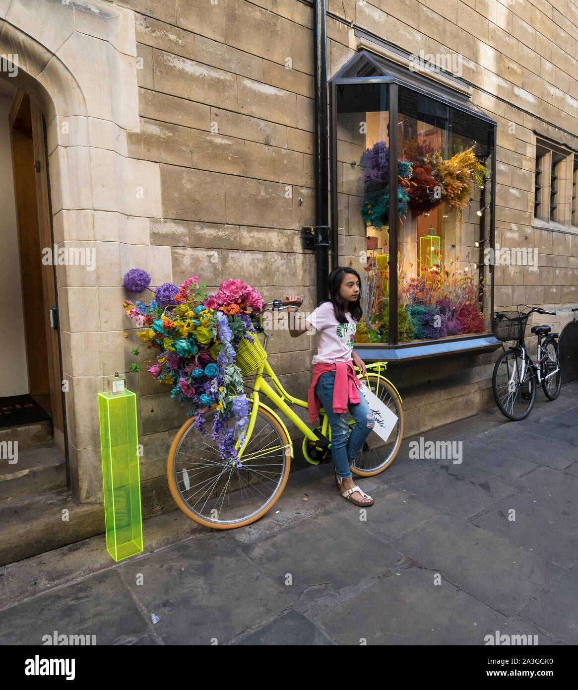 Young girl posing for photo by advertisement bike Cambridge 2019 Stock Photo