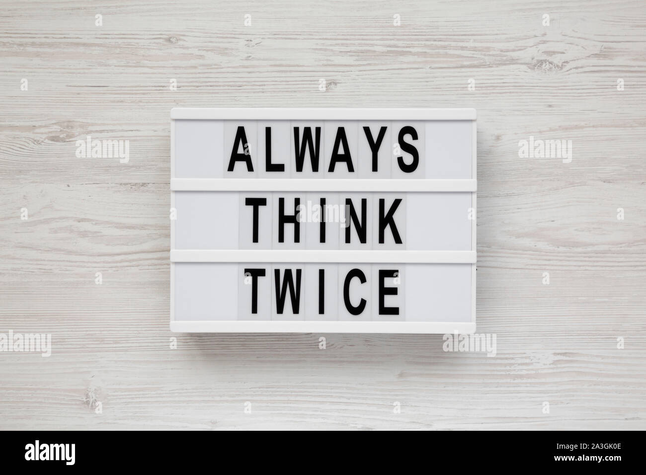 'Always think twice' words on a lightbox on a white wooden background ...