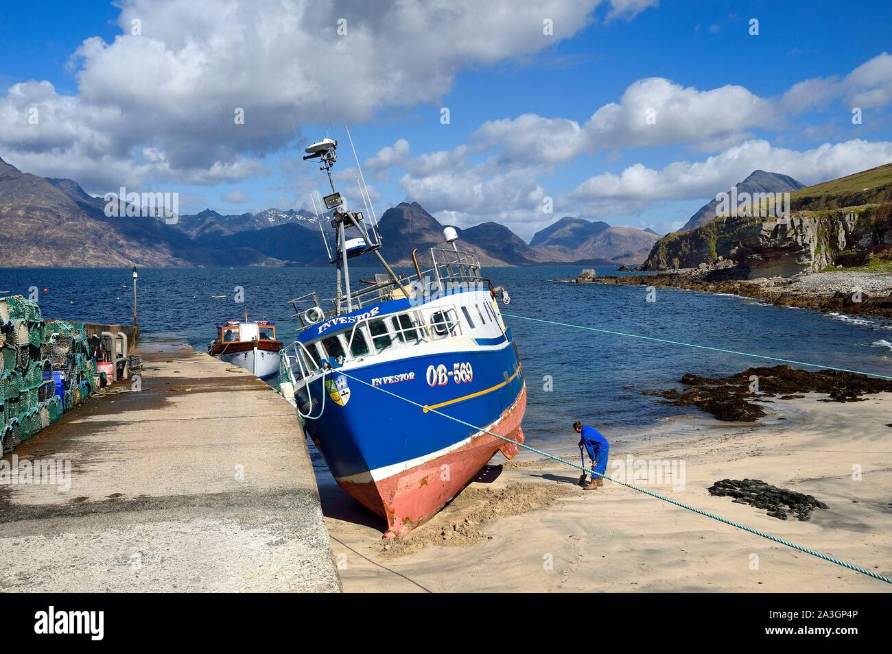 United Kingdom, Scotland, Highlands, Hebrides, Isle of Skye, fishing boat in the small port of the Elgol village on the shores of Loch Scavaig towards the end of the Strathaird peninsula and the Black Cuillin Mountains in the background Stock Photo