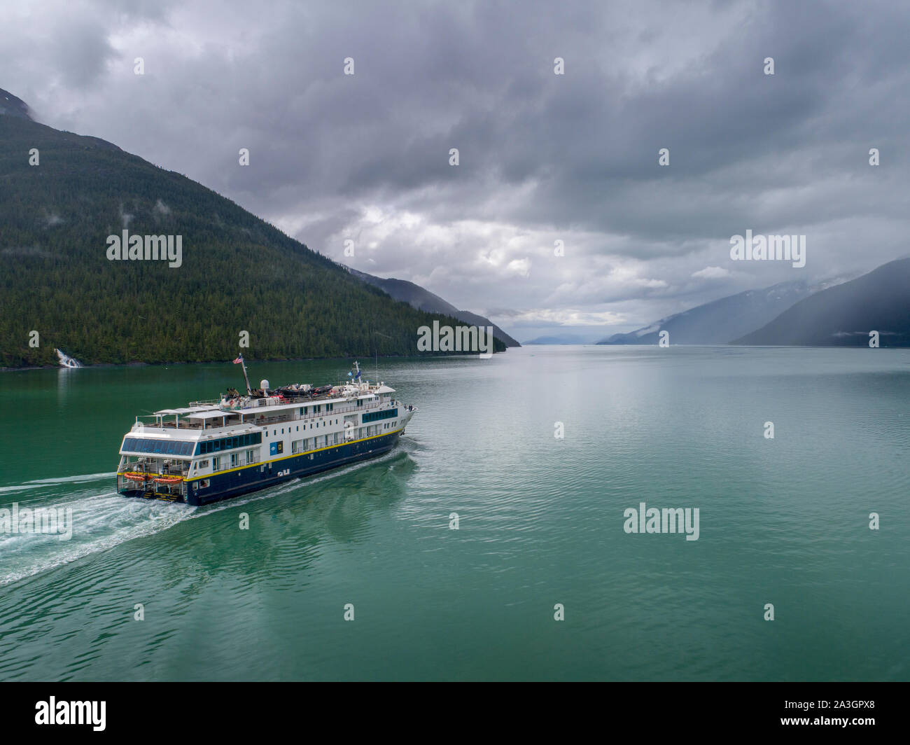 USA, Alaska, Tracy Arm - Fords Terror Wilderness, Aerial view of cruise ship National Geographic Quest motoring in Endicott Arm on summer afternoon Stock Photo