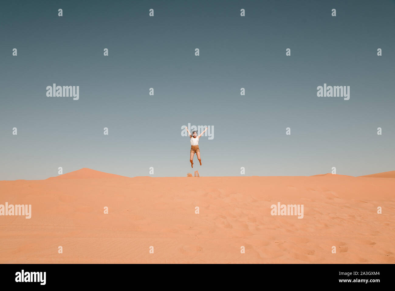 young woman jumping on a sand dune in the Sahara desert Stock Photo - Alamy