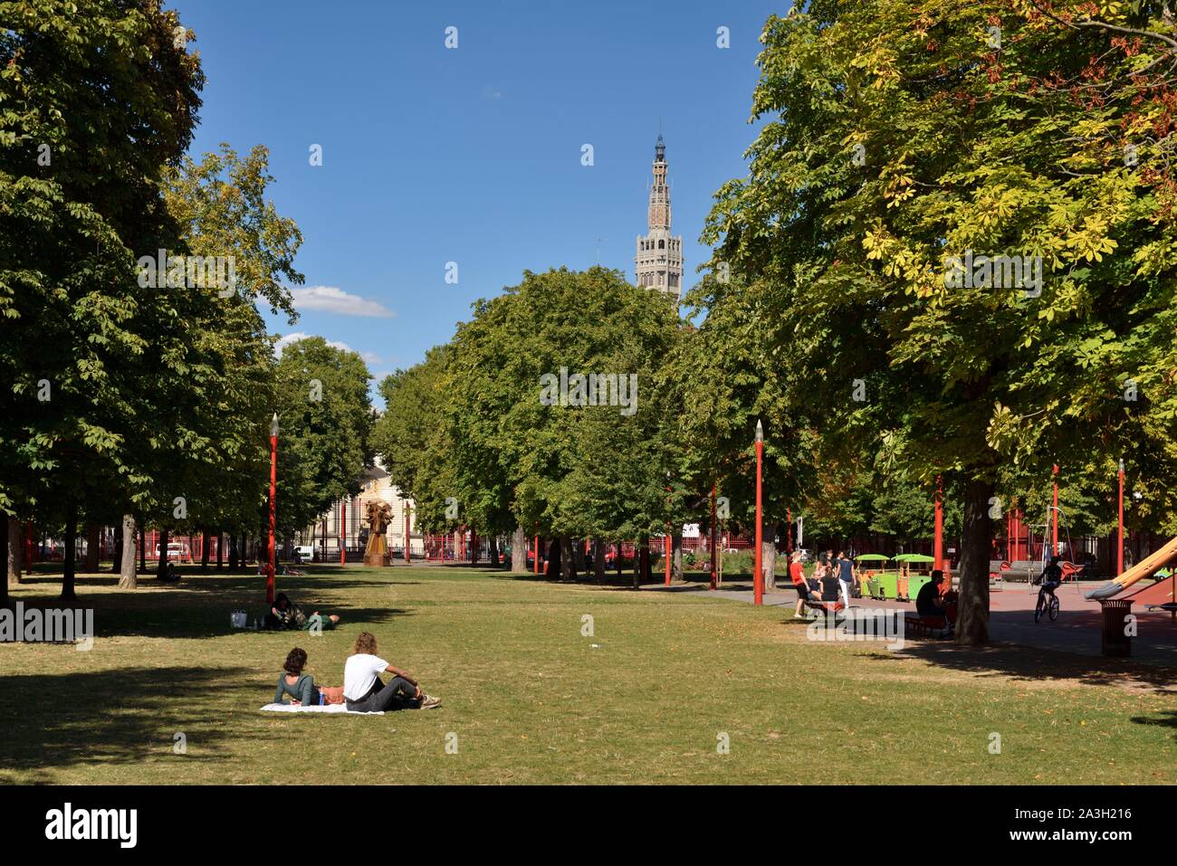 France, Nord, Lille, Jean Baptiste Lebas park with characteristic red  grilles dominated by the belfry listed as World Heritage by UNESCO and  which houses the services of the town hall, couple on
