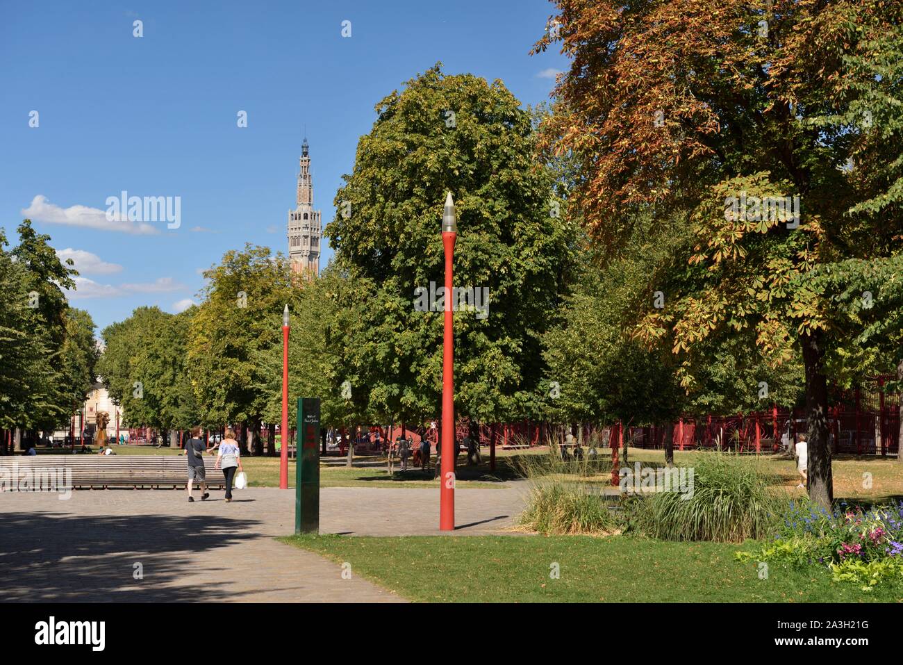 France, Nord, Lille, Jean Baptiste Lebas park with characteristic red  grilles dominated by the belfry listed as World Heritage by UNESCO and  which houses the services of the town hall, two people
