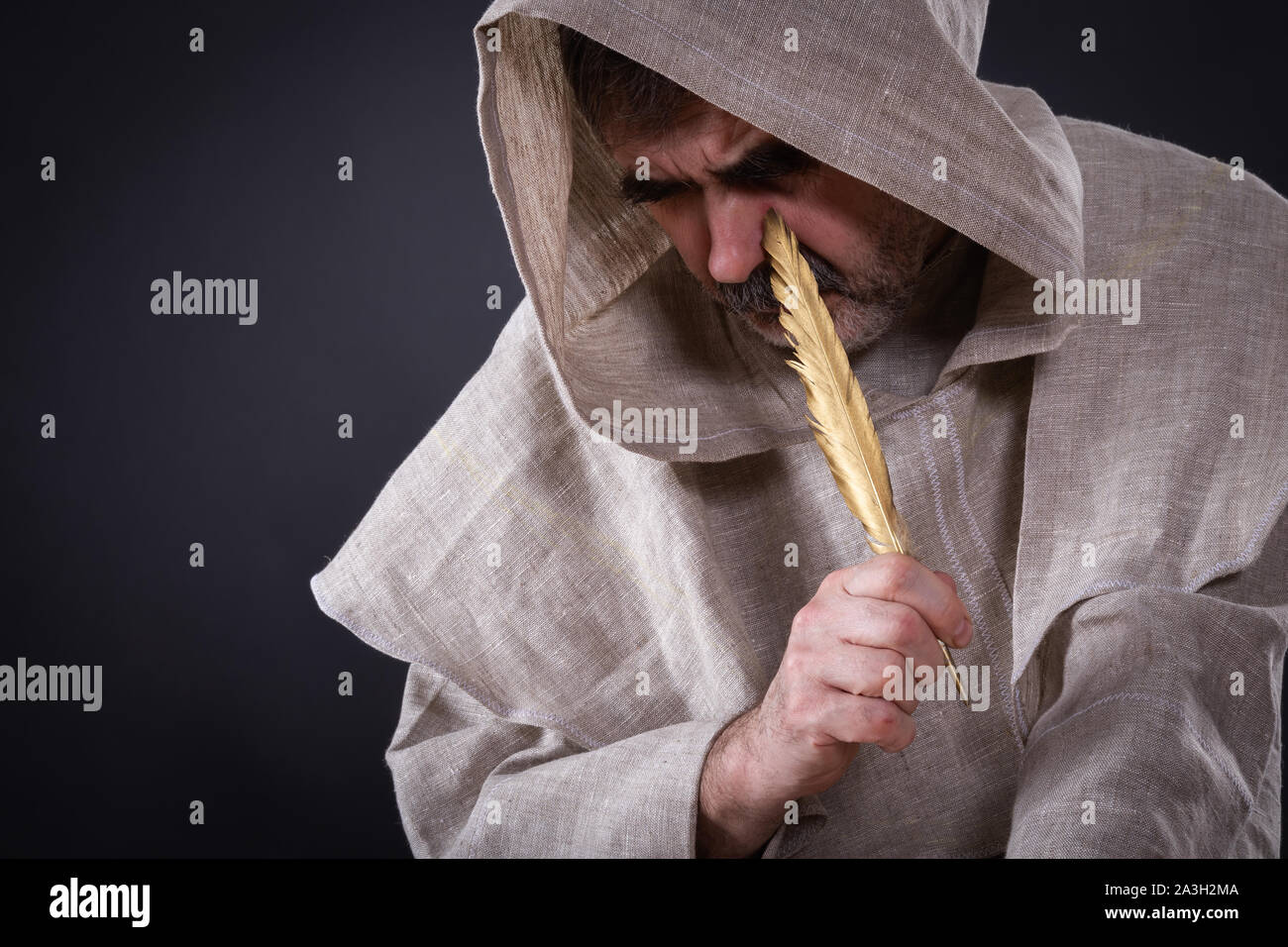 The monk alchemist was very thoughtful about writing a scientific manuscript on alchemy Stock Photo