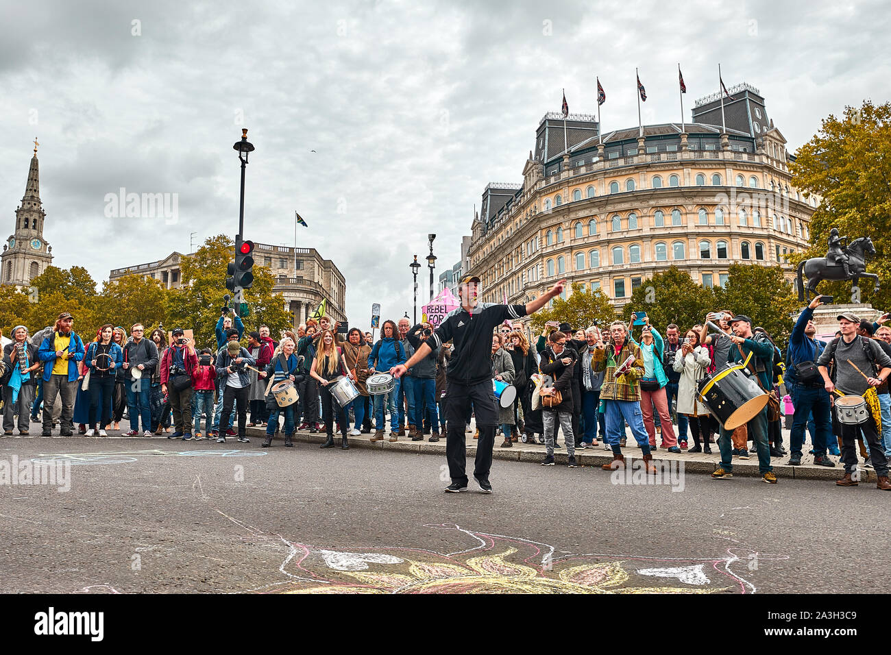 London, U.K. - Oct 8, 2019: A man leads drummers in an impromptu display on the second day of an occupation of Trafalgar Square by campaigners from Extinction Rebellion. Stock Photo