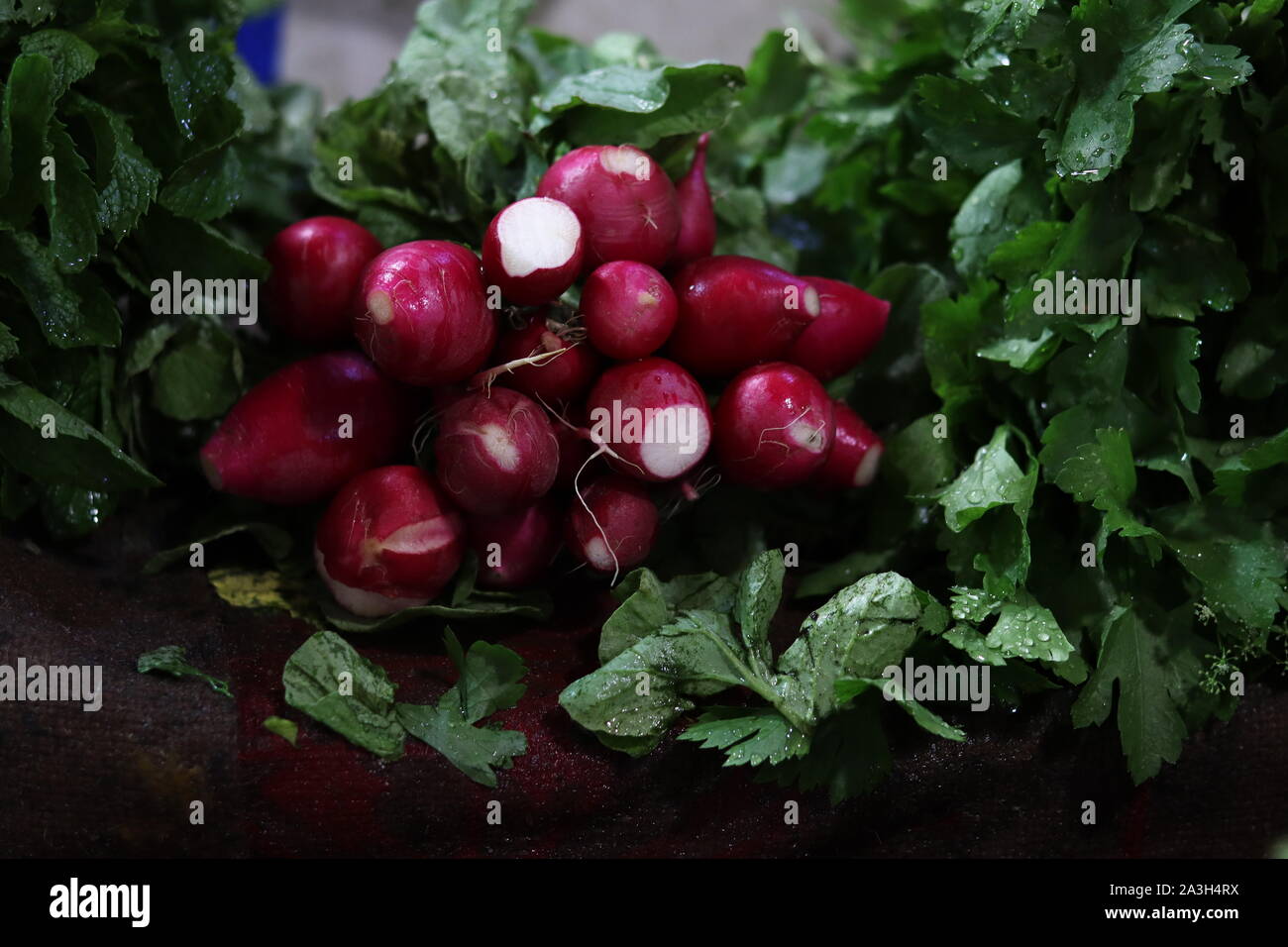 Radishes with green leaves on display in market Stock Photo