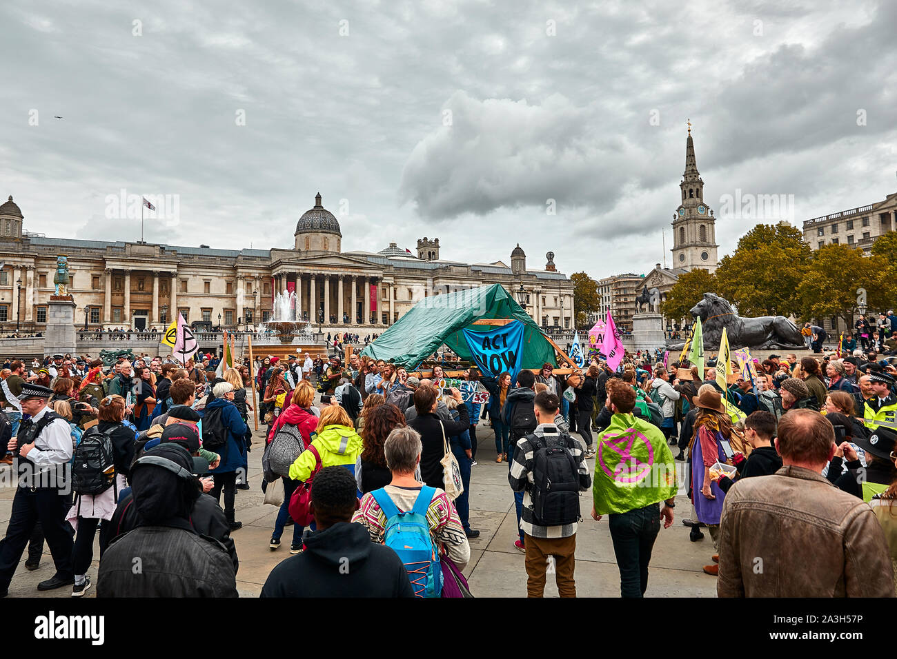 London, U.K. - Oct 8, 2019: Crowds surround a wooden canopy erected on the second day of an occupation of Trafalgar Square by campaigners from Extinction Rebellion. Stock Photo