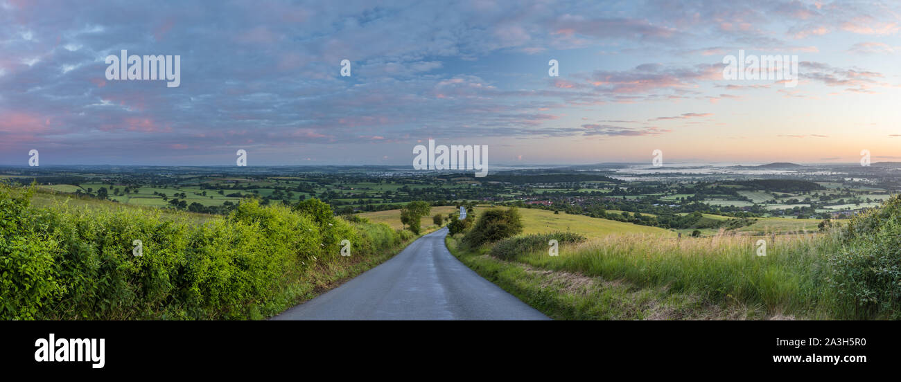 The road to Okeford Fitzpaine; dawn on the longest day in the Blackmore Vale, from Okeford Hill, Dorset, England, UK Stock Photo