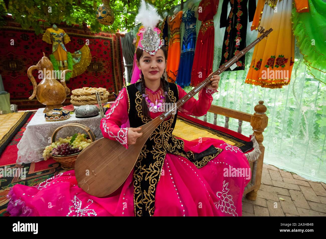 China, Xinjiang autonomous region, Turfan or Turpan, grape valley, kaluts museum, or subterranean irrigation chanels, woman in costume playing the d?tar, or traditional luth Stock Photo
