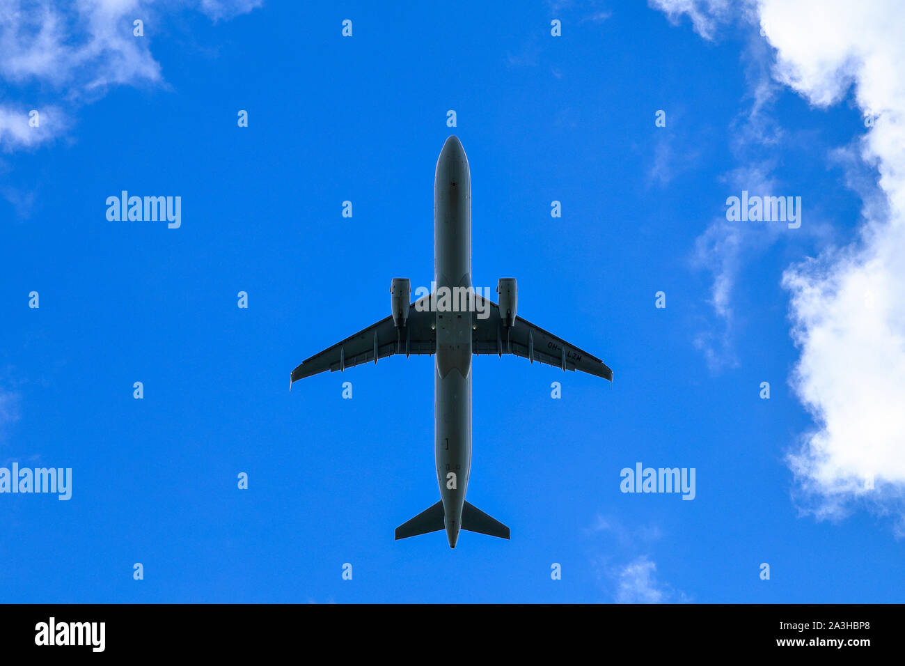 Airplane flying against blue sky Stock Photo