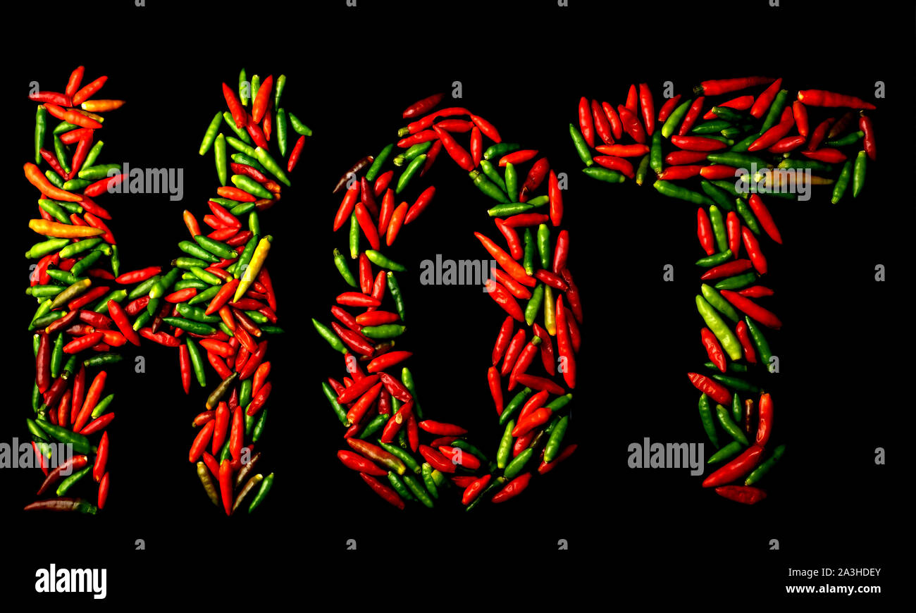 Group of chili pepper shape HOT english words at black background Stock