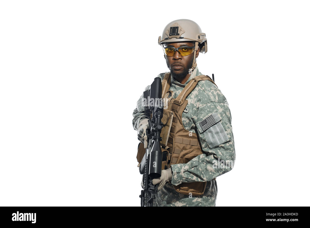 Front view of American soldier with weapon in hands and seriously looking at camera. African man wearing body armour and uniform waiting for instructions for battle. Concept of war and army. Stock Photo