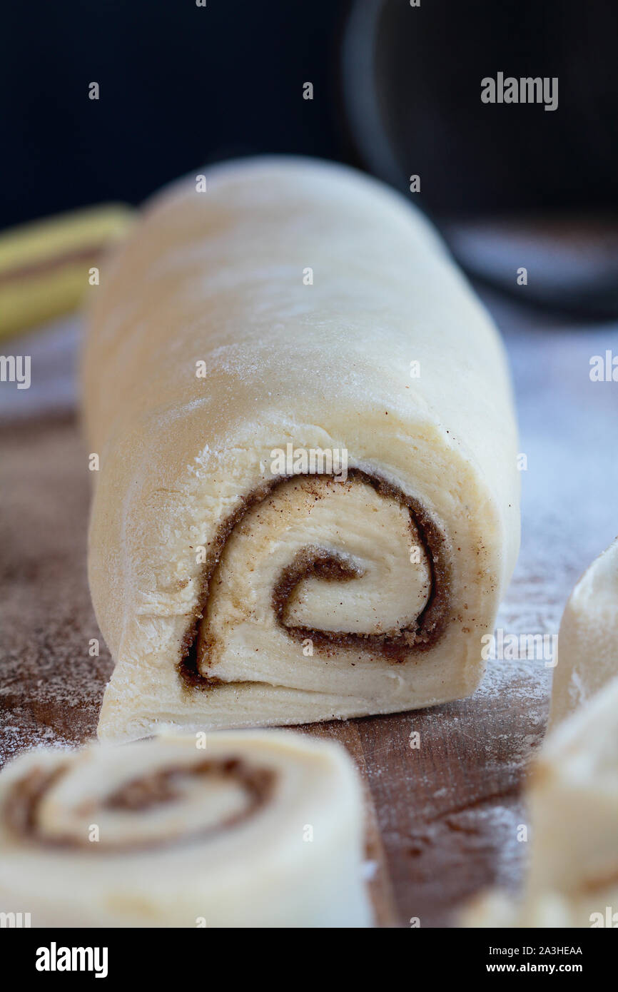 Homemade cinnamon roll dough over a floured surface with duster in background. Selective focus with blurred foreground and background. Stock Photo