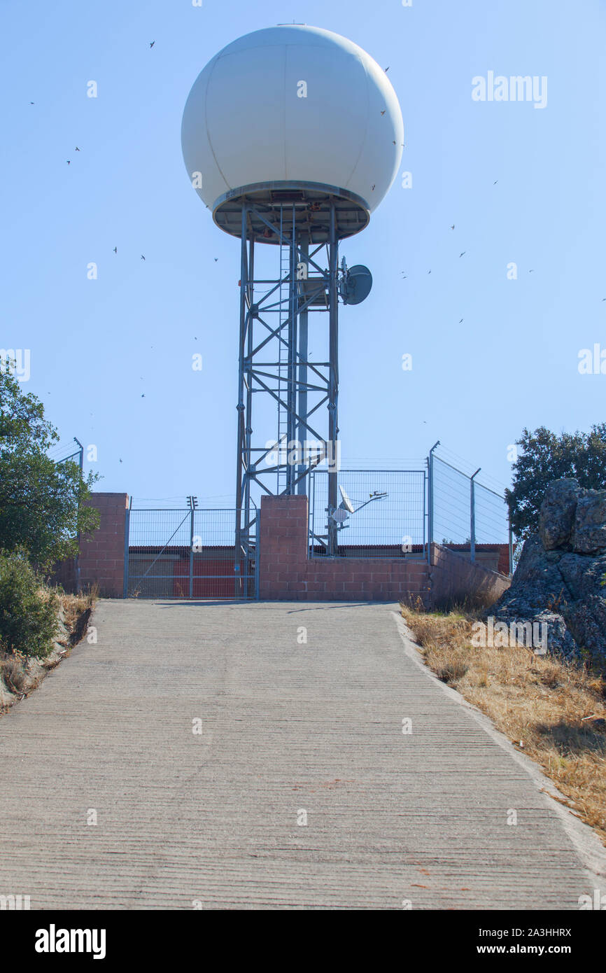 Meteorological radar station on the top of Sierra de Fuentes, Spain, SPA area. Swallows flying arround over blue sky Stock Photo