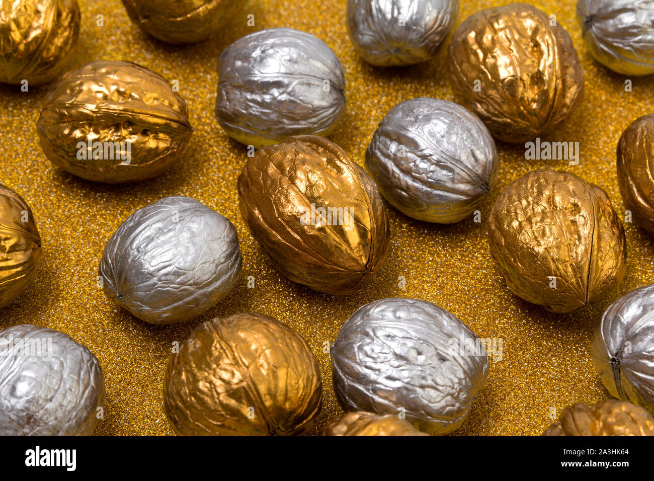 Painted golden and silver walnuts on glittering background Stock Photo