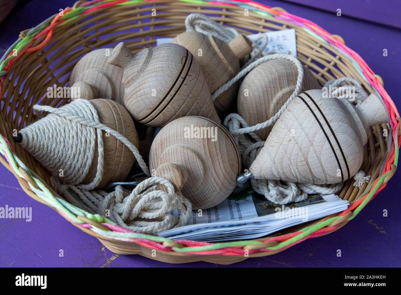 Wicker basket in the market full of wooden tops. Spain Stock Photo