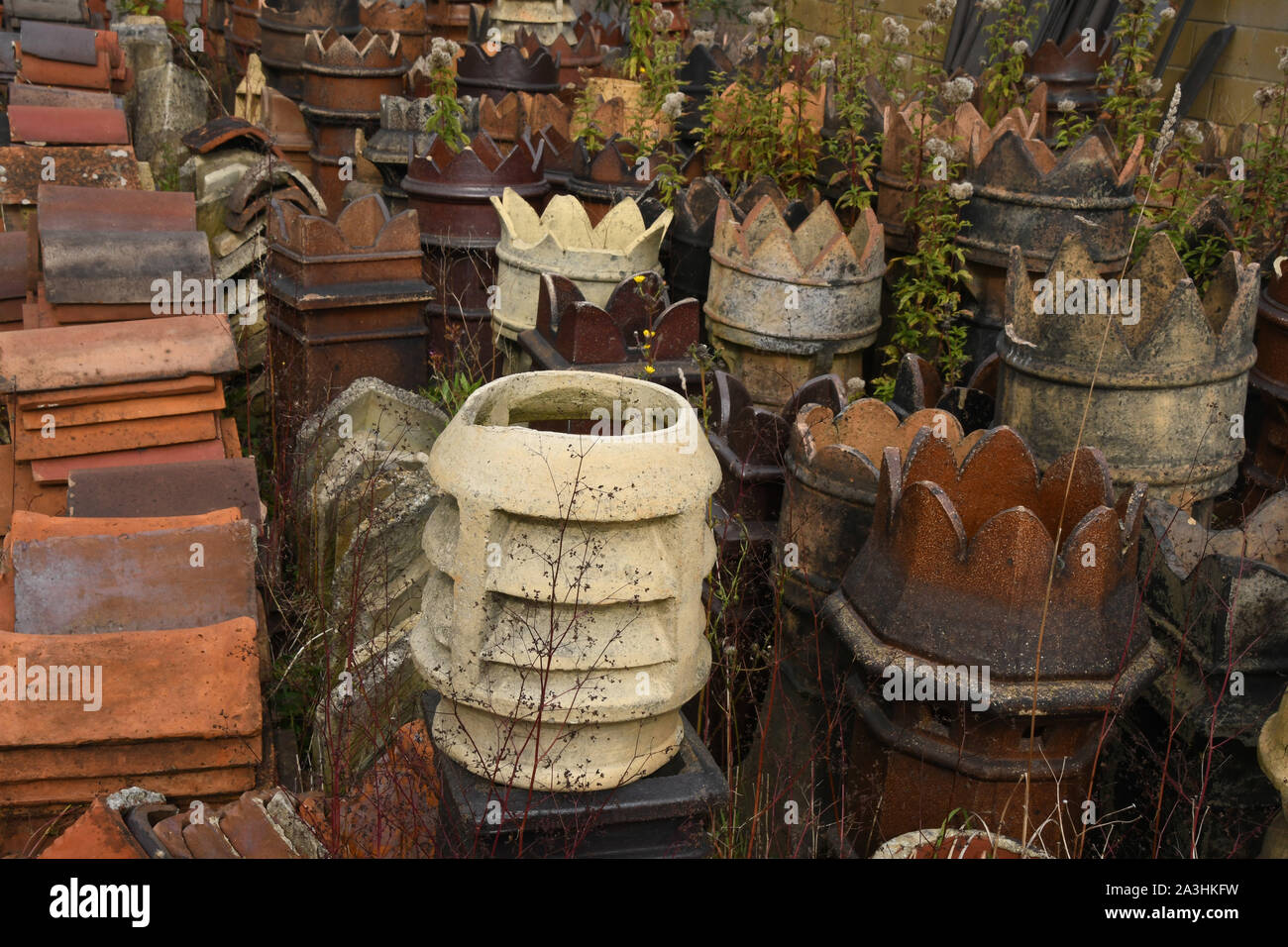 Interesting Victorian chimney pots and ridge tiles in an English west country architectural salvage yard. Stock Photo