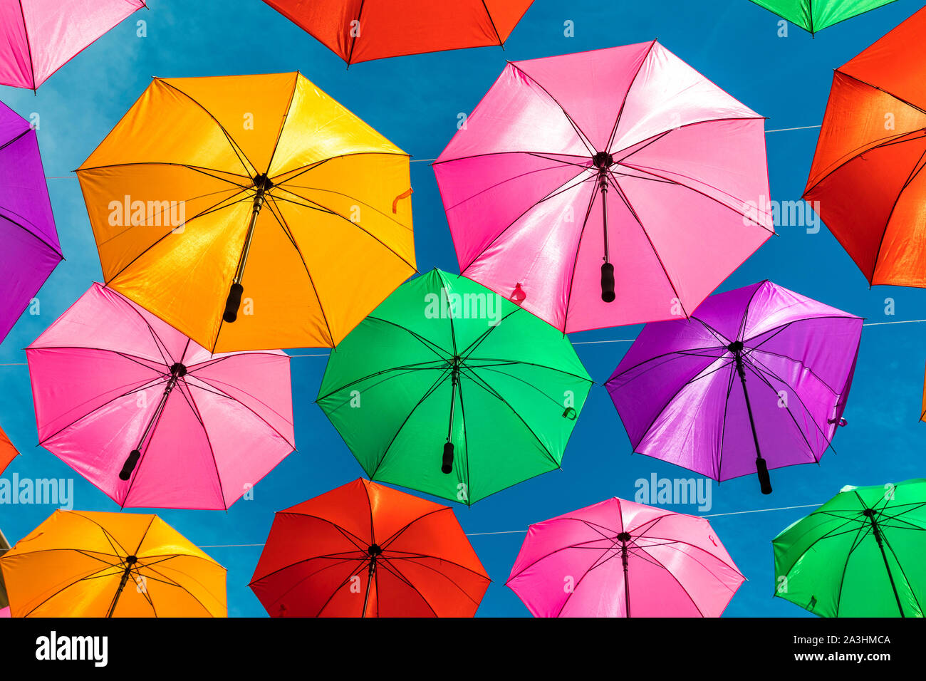 Brightly colored umbrellas provide shade over an outdoor shopping plaza