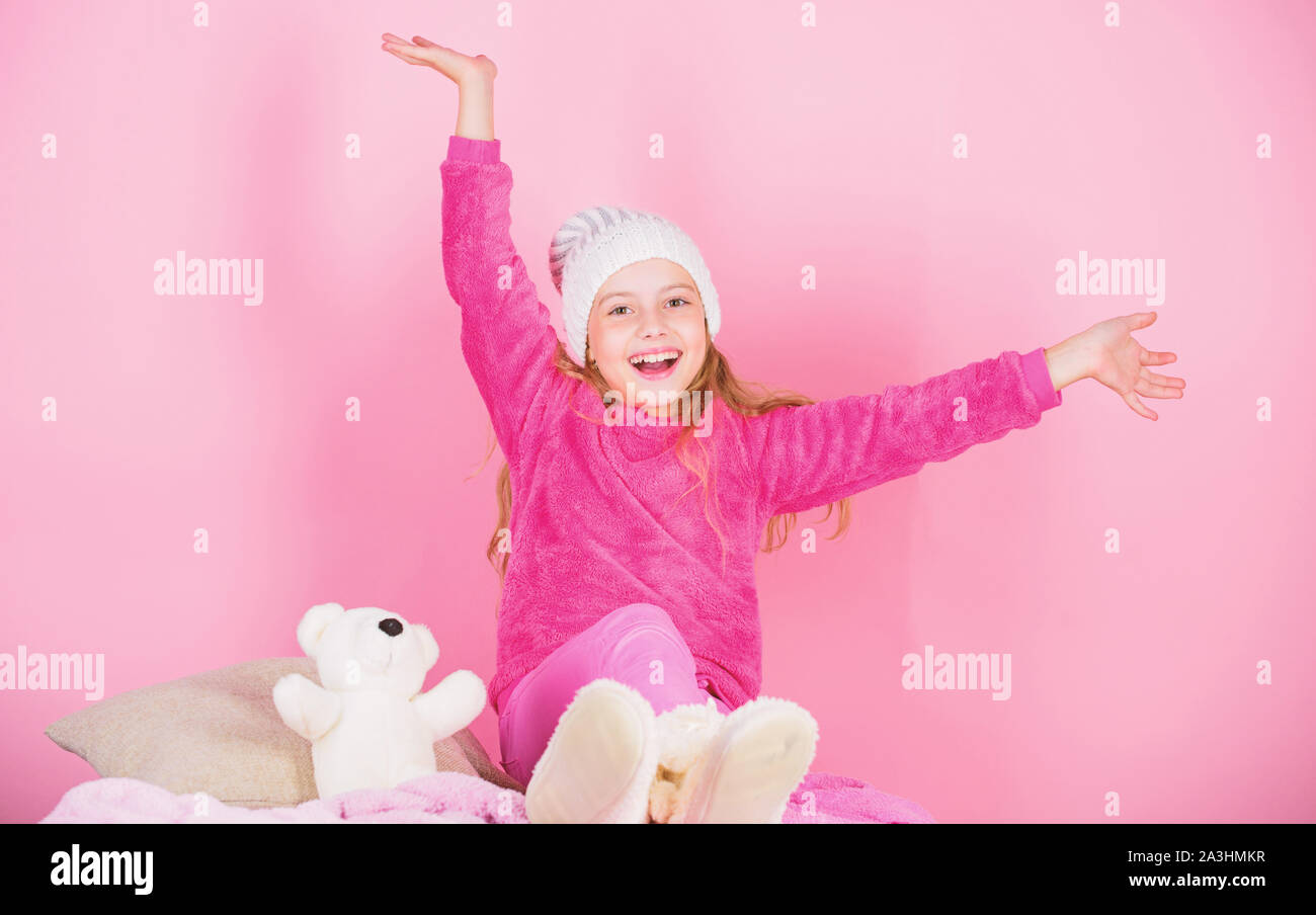 Kid cute girl play with soft toy teddy bear pink background. Unique attachments to stuffed